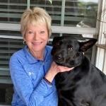 Linda peterson sits next to her black dog